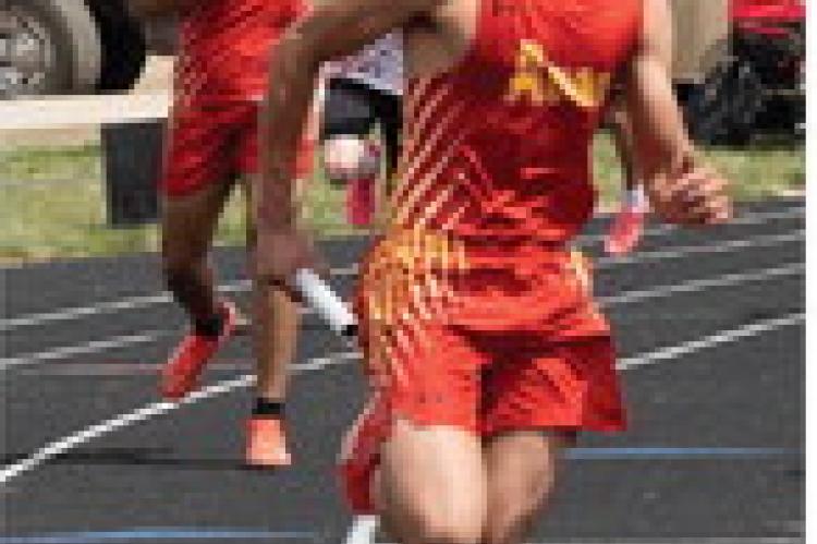 John Fathke receives baton from teammate Aziah Meyer and takes off down the track during the relay race.