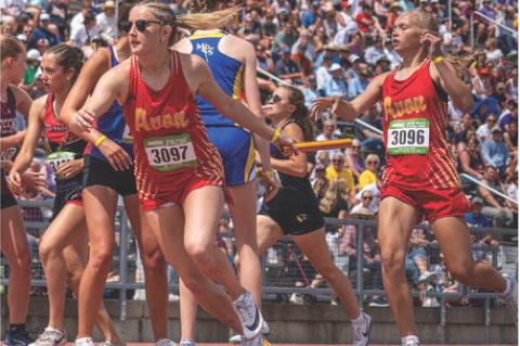 Emersyn Haenfler hands off the baton to Hadlee Kracht in the 4x800 relay where the girls earned 13th on Day 1 to end their season. Photo courtesy of South Dakota Public Broadcasting/Aidan DeBoer