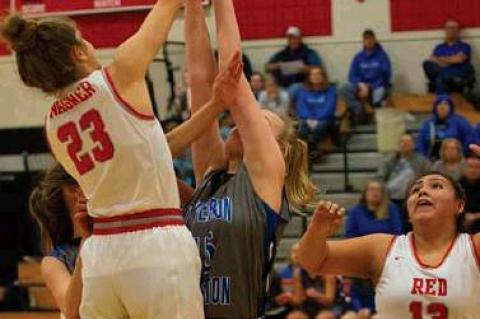 #23 Abby Brunsing fakes a shot and passes the ball to #13 Deisha Medicine Horn  .