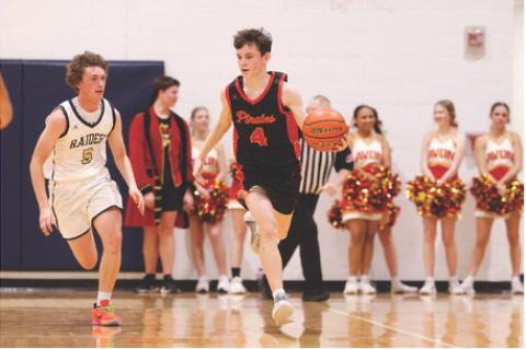 Zander Fathke brings the ball down the court as the Raiders defense closes in.