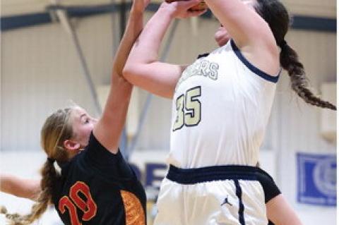Brielle Voigt elevates to defend the basket with a block attempt.